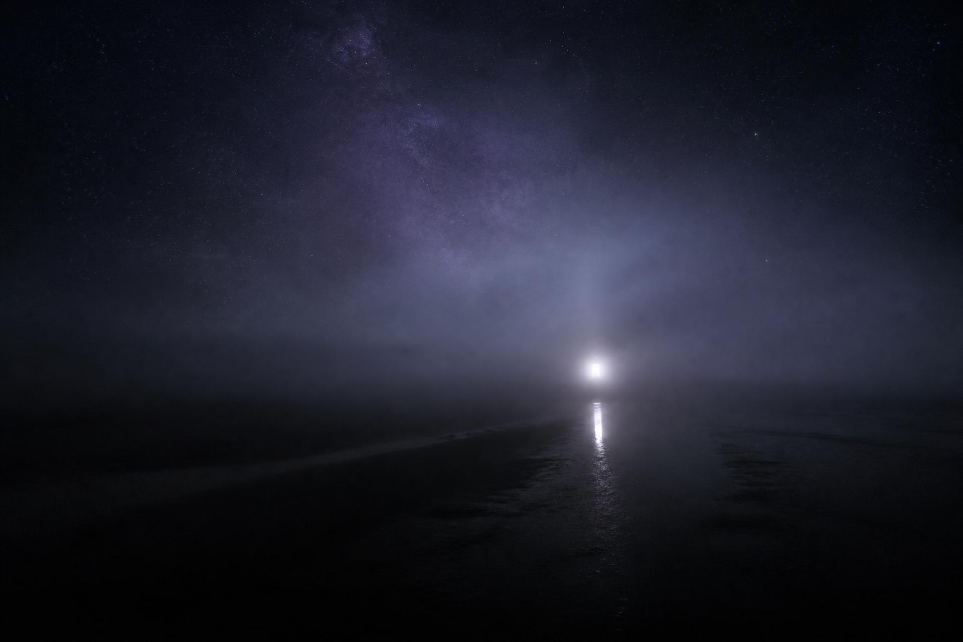 Nebel über dunklem Wasser unter einem Sternenhimmel